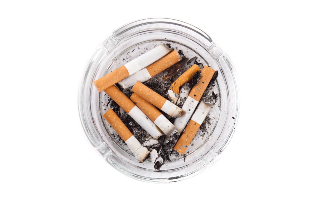 Glass ashtray filled with used cigarettes