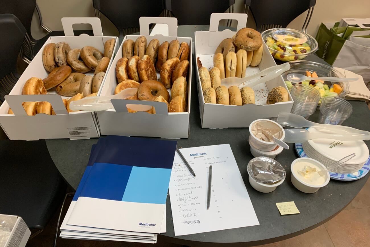 Large open boxes of bagels on a round table