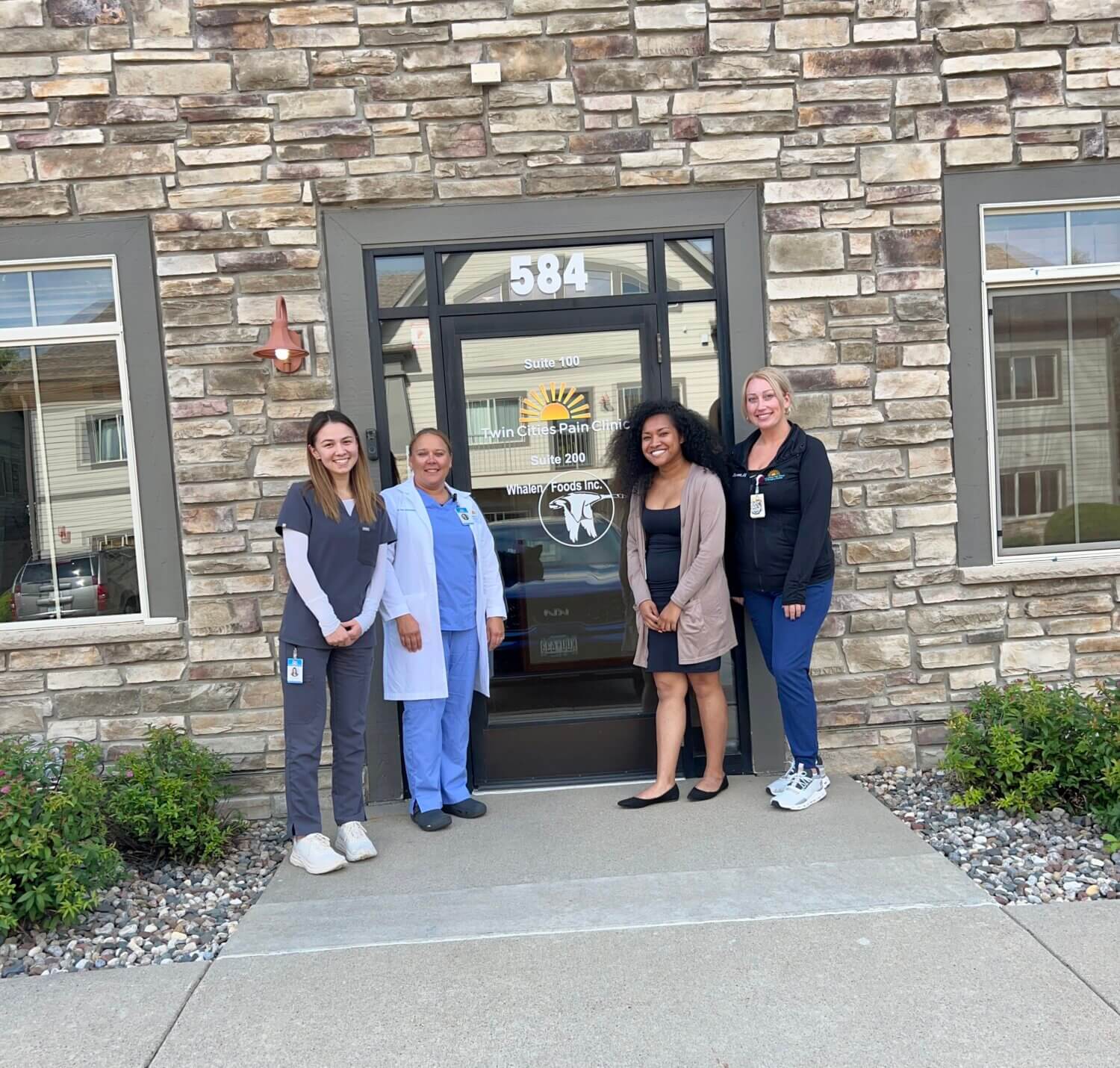 Clinic team at front entrance of Twin Cities Pain Clinic in Chaska, MN