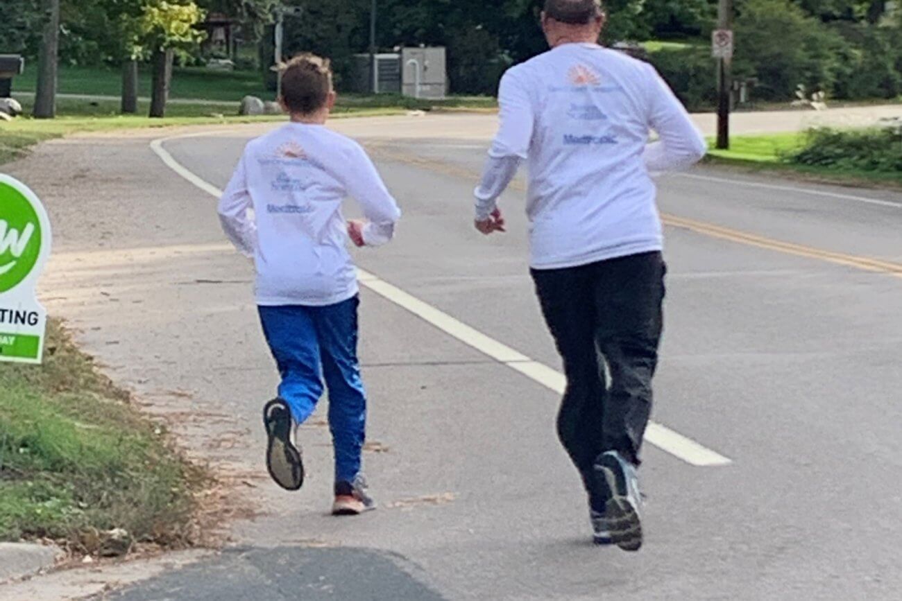 Twin Cities Pain Clinic employee and son running on street