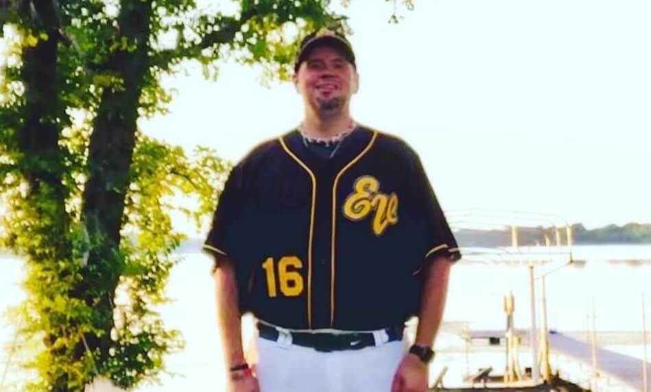 Troy Thielen in Eden Valley Hawks baseball uniform standing in front of a lake