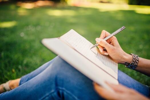 Close up of a hand writing in a chronic pain journal