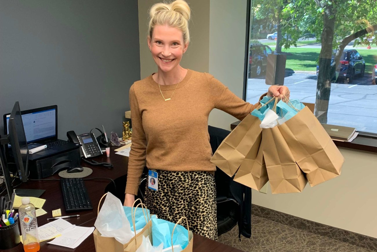 Twin Cities Pain Clinic human resources manager holding employee appreciation gift bags