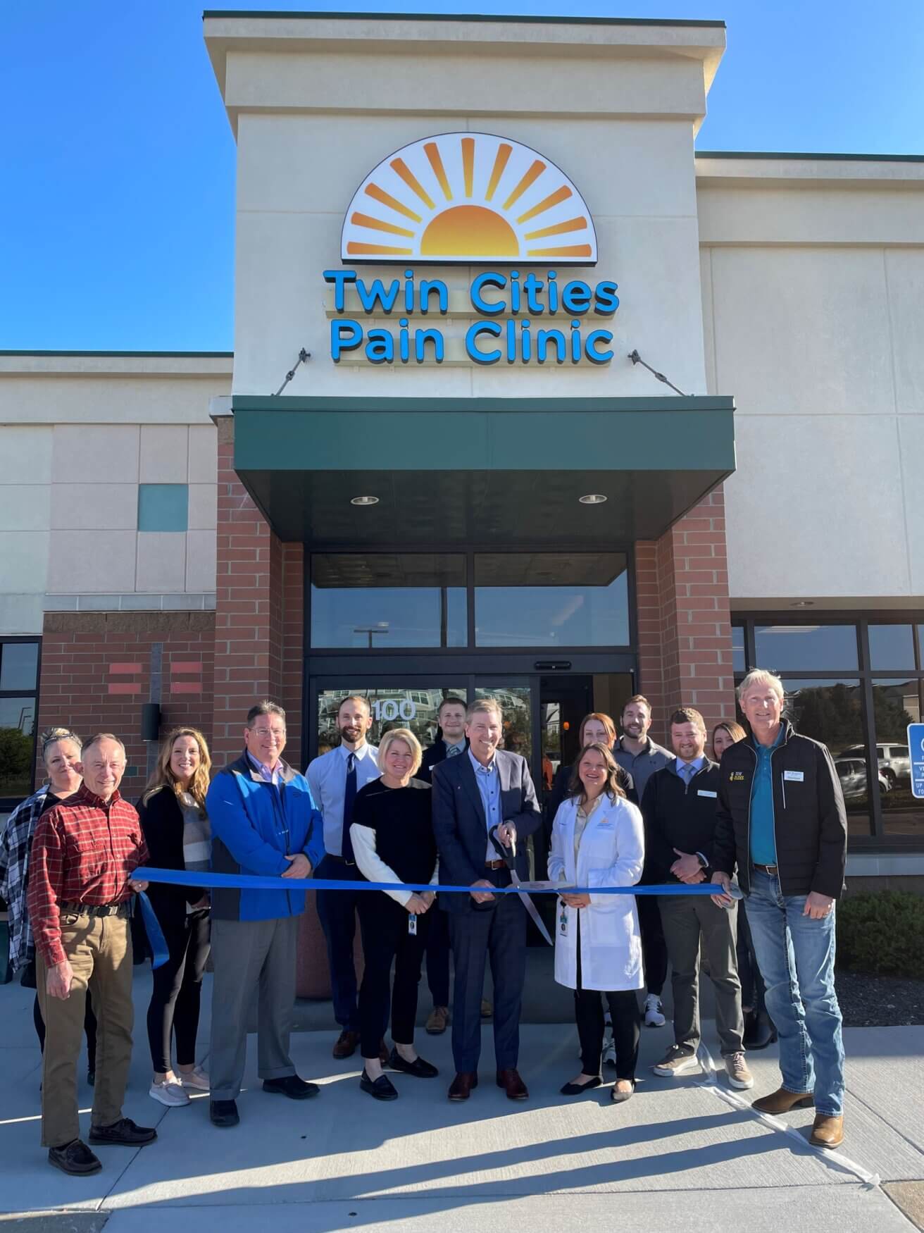 Pain clinic team and chamber representatives pose for the ribbon cutting at Twin Cities Pain Clinic in Maplewood, MN