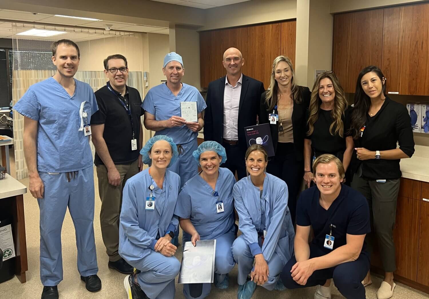 Surgical team posing together in nursing station at surgery center