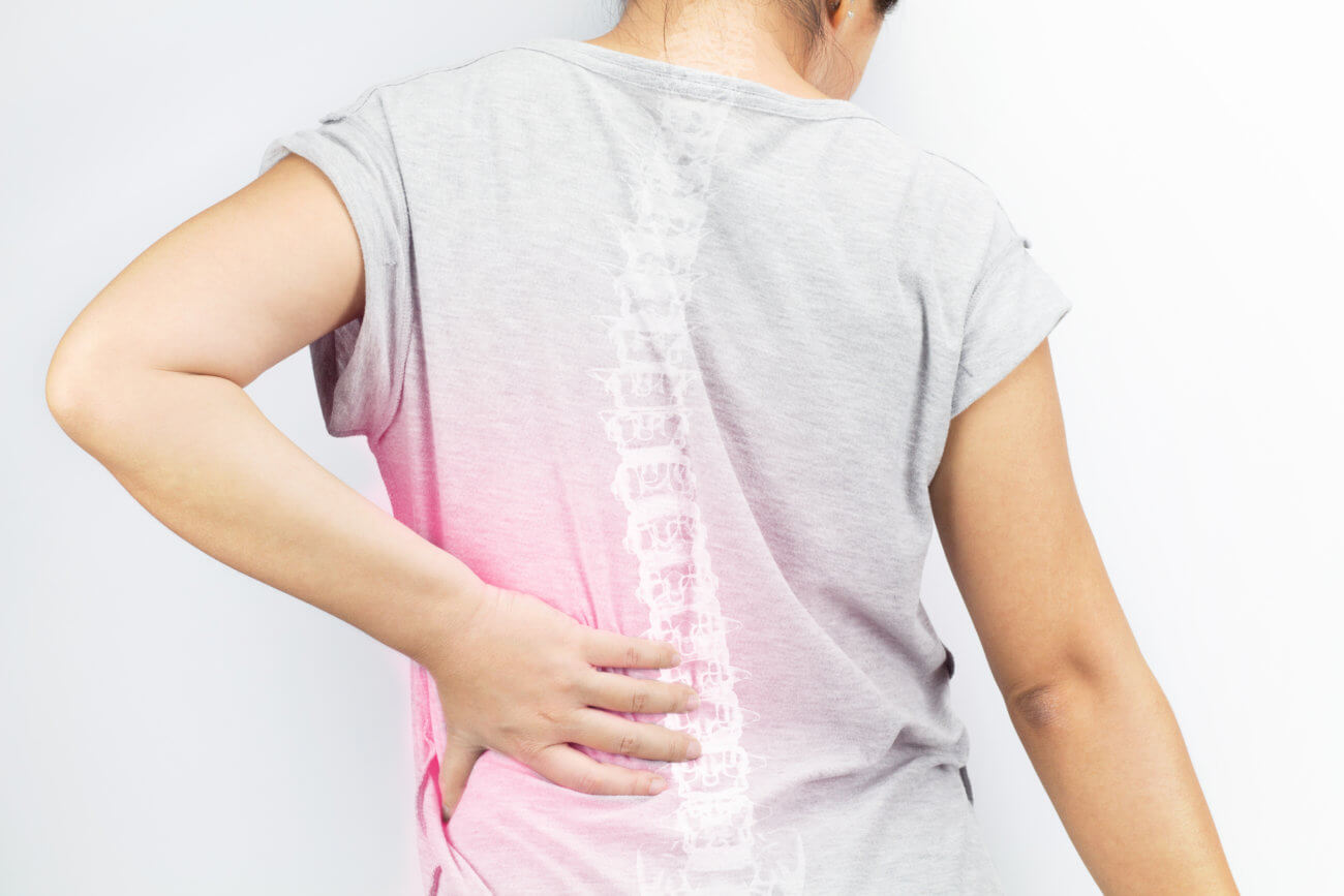 Woman with hand on spine which is glowing red to indicate pain